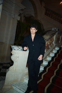a man in a suit standing on a staircase